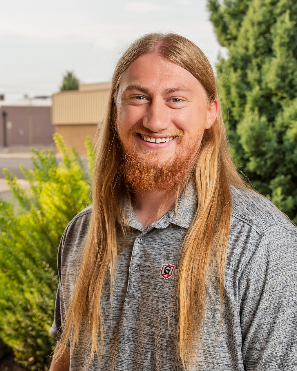 Smiling man with long hair outdoors