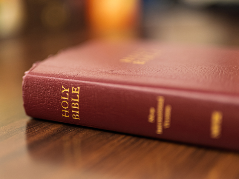 Close-up of Holy Bible on wooden table.
