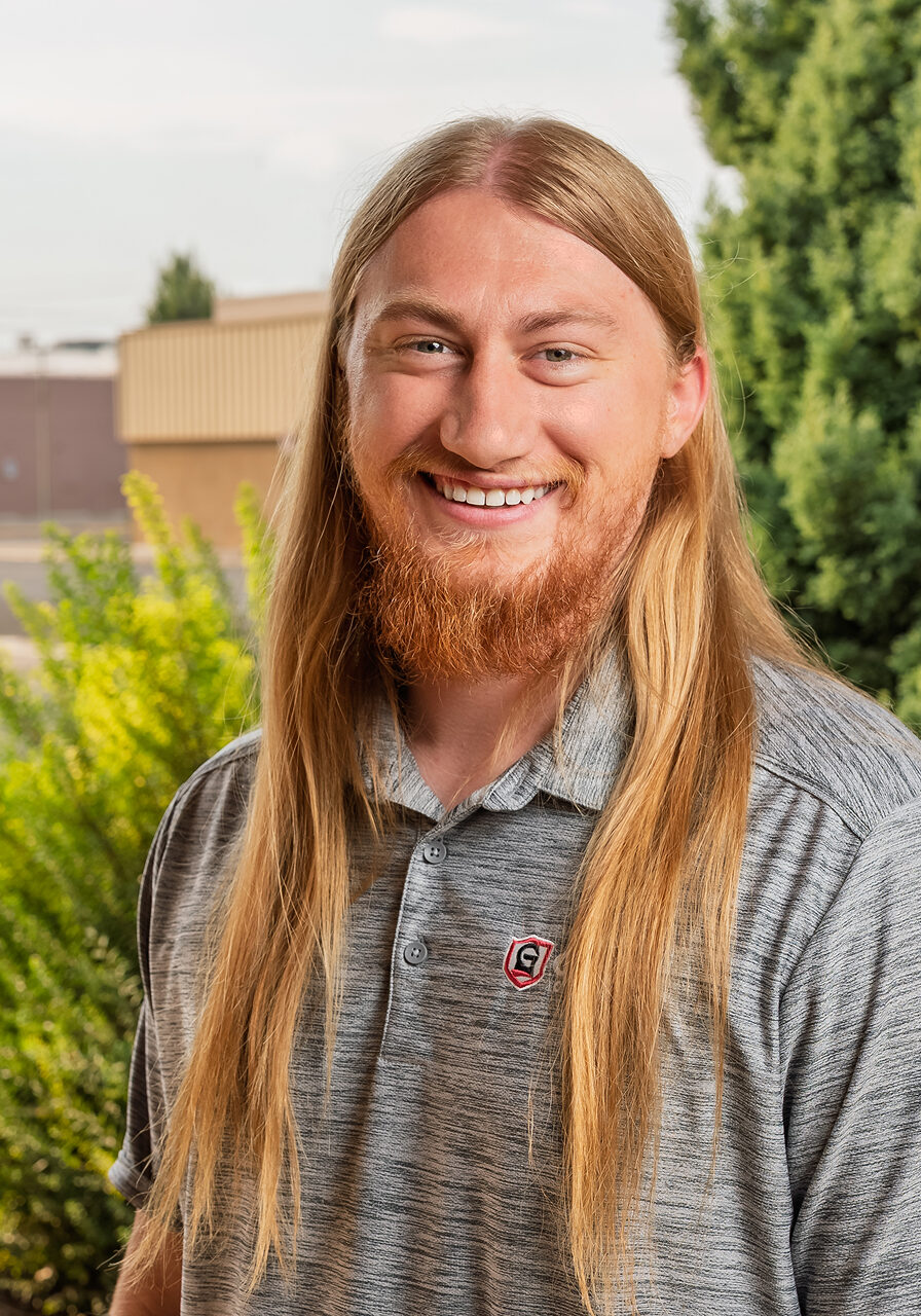 Smiling man with long hair outdoors